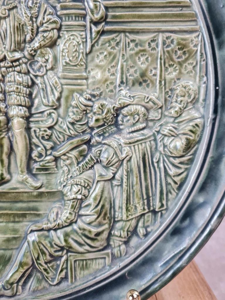Assiette murale ancienne en céramique verte – scène historique en relief – Ø 25 cm