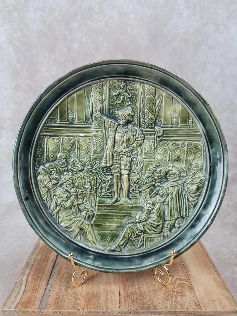 Assiette murale ancienne en céramique verte – scène historique en relief – Ø 25 cm